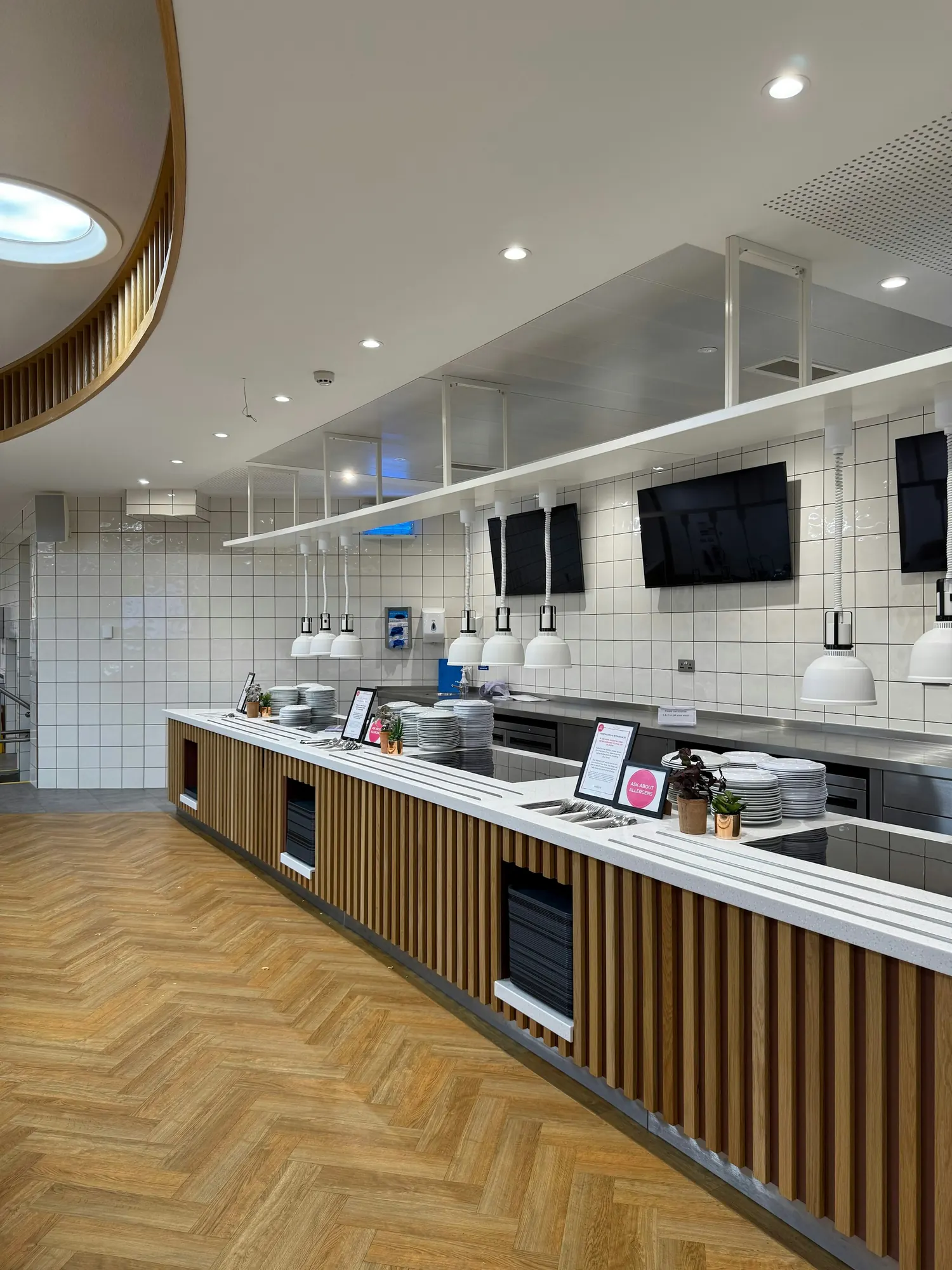 A commercial cafeteria serving counter with white tile