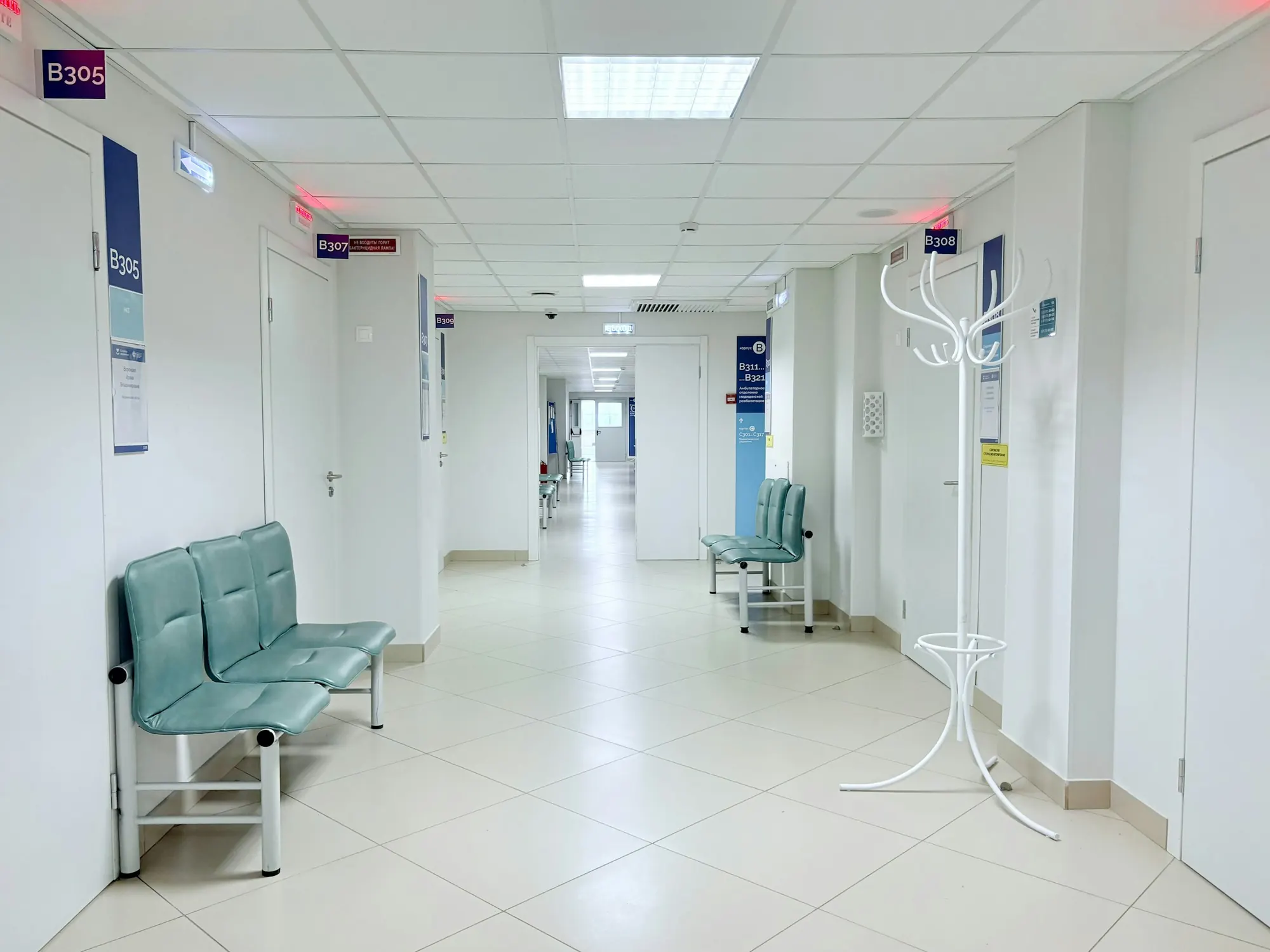 A bright clinic corridor with a tiled floor