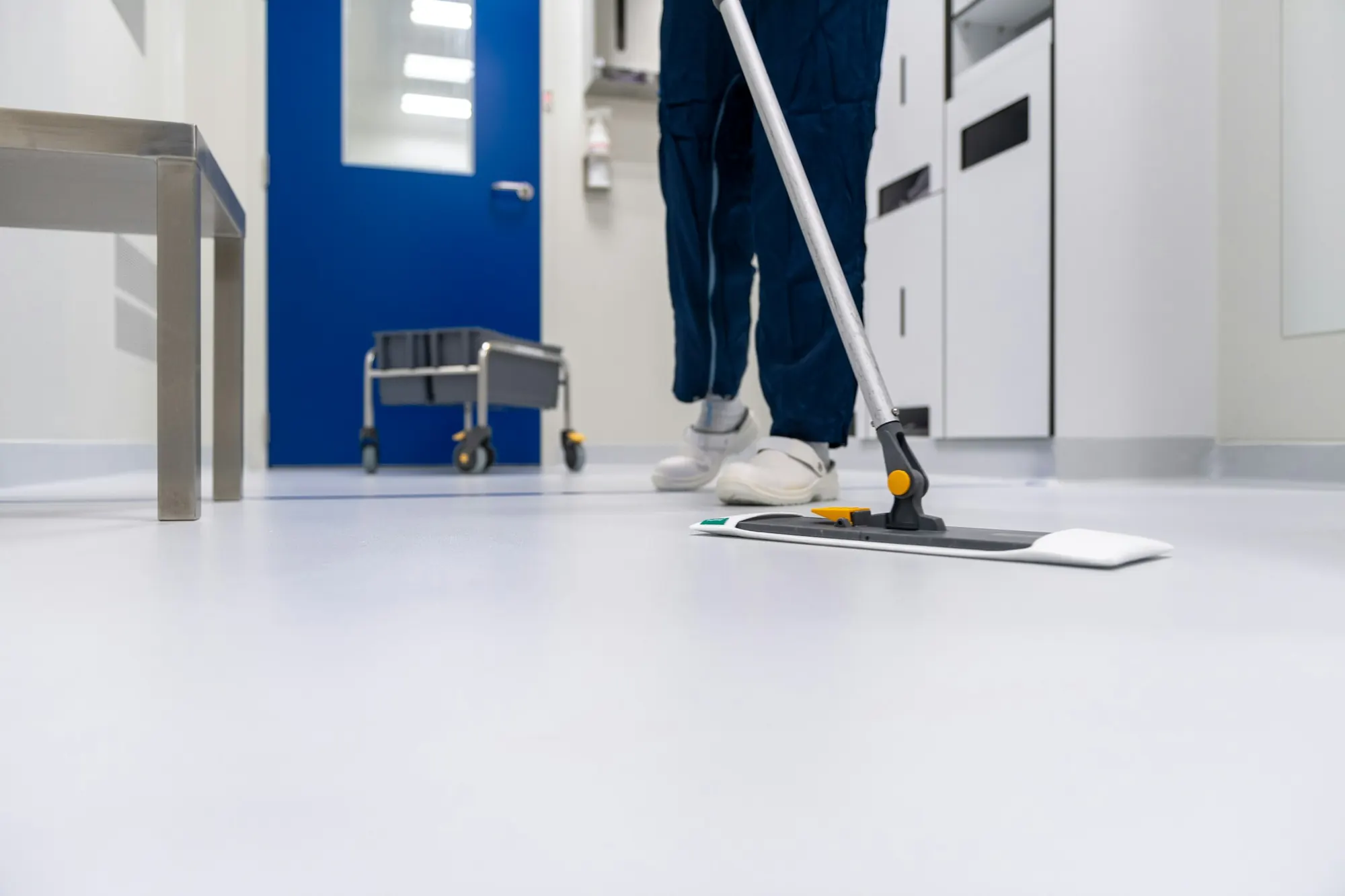 A cleaner working on a bright tiled floor
