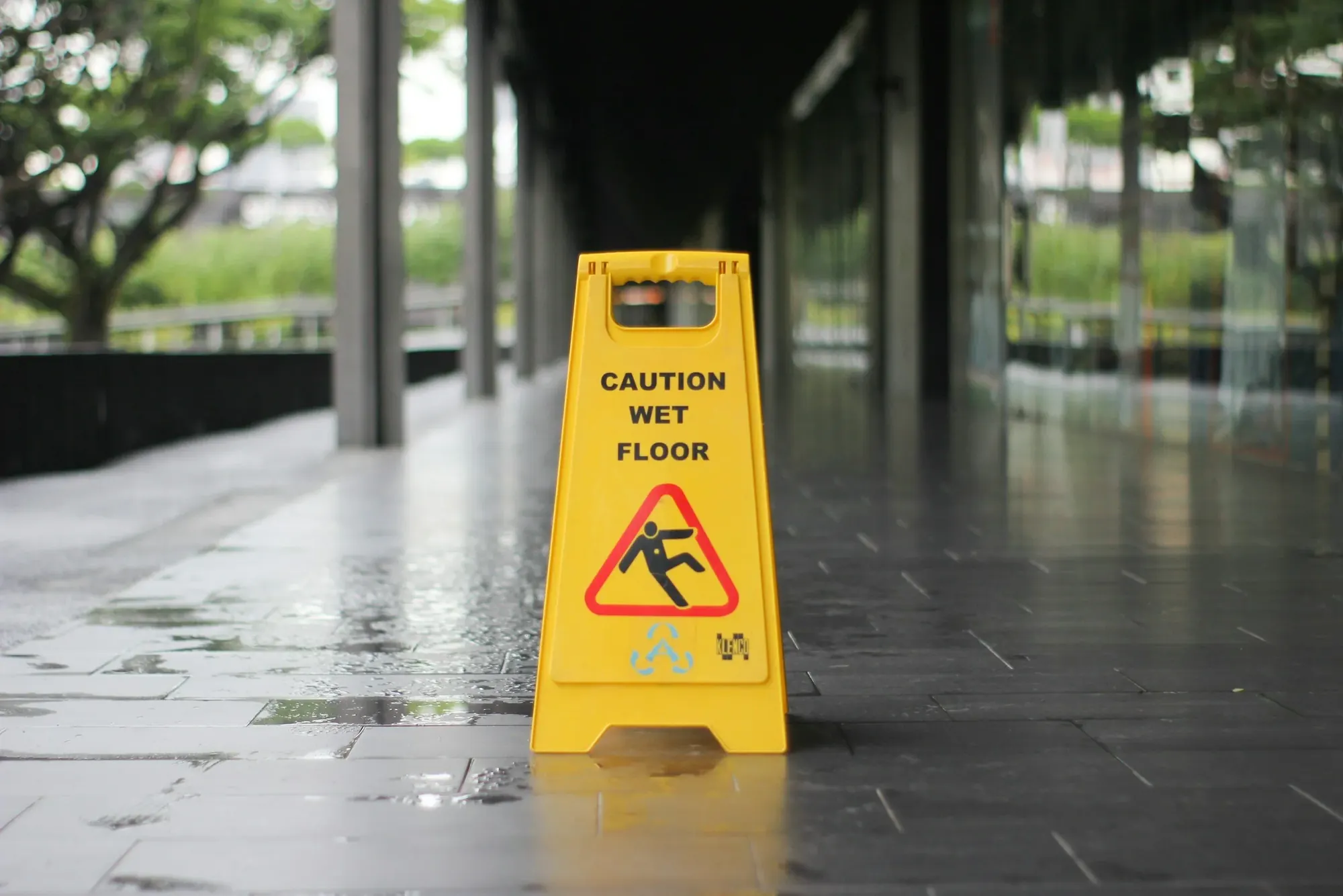 A yellow wet floor sign in a commercial corridor